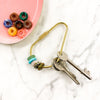 Crystal donut keyring with green aventurine, turquoise, rose quartz, dalmatian jasper and indian agate. Other crystals also in separate bowl.